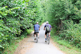 1270 Radweg am Rande des Heidkoppelmoors in Hoiesbttel / Ammersbek - zwei Radfahrer bei einer Radtour durch das Naturschutzgebiet.