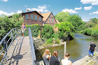 9312 Fussgngerbrcke ber die Trave - Jugendliche sitzen am Flussufer in Bad Oldesloe, Kreis Stormarn.