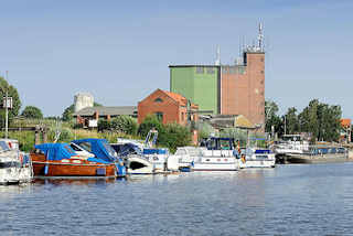 5851 Hafen von Bleckede an der Elbe; Sportboote in der Marina, ein Binnenschiff liegt am Hafenkai. Speichergebude / Silo und Wohnhuser am Hafenrand.