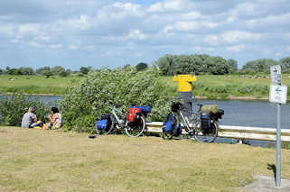 7233 Fahrradtour - Rast an der Elbe bei Bleckede; hoch bepackte Fahrrder / Fahrradtaschen - Picknick am Wasser.