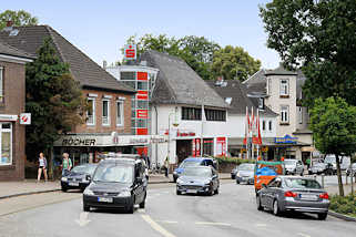 2611 Einkaufsstrasse in Reinbek, Bahnhofsstrasse; Einzelhuser mit Geschften - fahrende PKW / Autos.